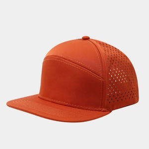 Detail of laser-cut perforations on orange flat brim baseball cap for breathability