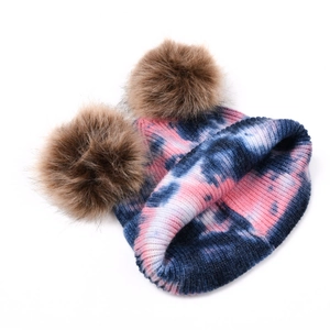 Détail du bonnet en tricot tie-dye avec deux pompons en fausse fourrure marron