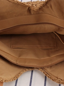 Hollow woven shoulder bag featuring a brown fabric lining with zipper closure and inner pocket