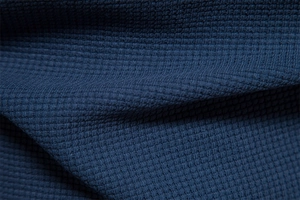 Detailed macro view of navy blue waffle knit texture on men's long sleeve cotton T-shirt