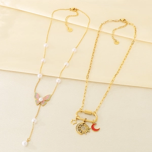 Detail of 18K gold-plated layered necklaces with butterfly, moon, and sun charms