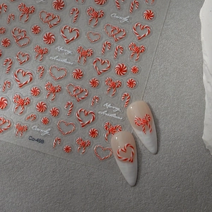 Macro shot of candy cane nail stickers with ultra-thin red and white festive designs