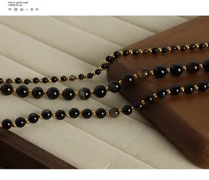 Detailed macro shot of natural agate beads with gold spacers on a beige velvet jewelry tray