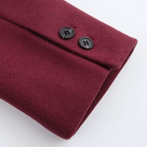 Close-up of wine red wool coat cuff with two black resin buttons and fabric texture