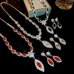 Detailed view of luxury jewelry sets with crystal flower pendants in green, silver, and red