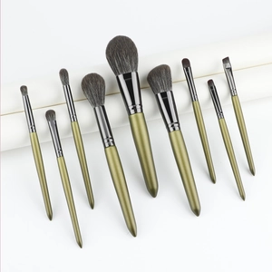 Detail of 9-piece makeup brush set featuring olive green handles and dense dark bristles