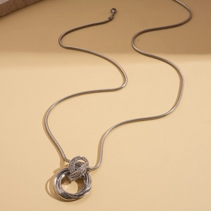 Detail of silver snake chain with interlocking circular pendants and textured finish