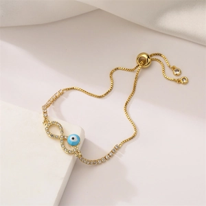 Detail of adjustable gold-plated evil eye and infinity bracelet with micro-pave crystals