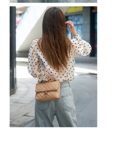 Details der hellbraunen Stepptasche mit goldener Kette und Metalldrehverschluss