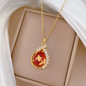 Elegant gold titanium teardrop necklace with red gemstone and floral crystal inlay