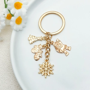 Close-up of golden Christmas keychain with Santa, tree, snowflake, and glove charms