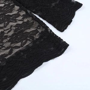 Detail of black floral lace fabric with scalloped edges and intricate mesh patterns