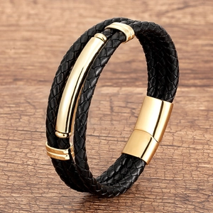 Detail of black braided leather bracelet with golden metal accents and magnetic clasp
