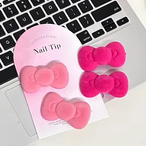 Pink flocked velvet bow hair clips shown on a laptop keyboard background