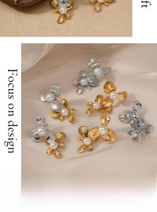 Detailed flat lay of gold and silver flower earrings with pearls on silk fabric