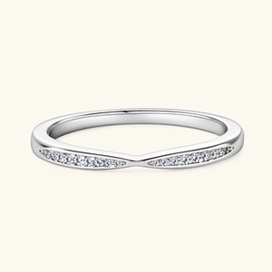 Macro shot of silver V-shaped ring with pavé-set zircons on a minimalist beige background