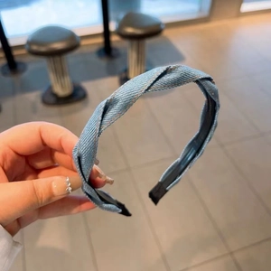 Detail of light blue denim twisted headband with subtle gold thread weave and inner lining