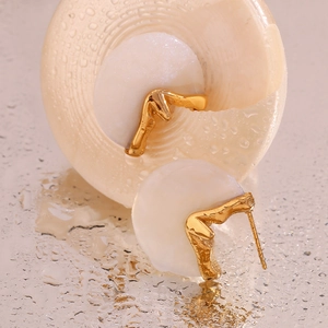 Detail of 18K gold-plated oval earrings with natural stone on a water-drop surface