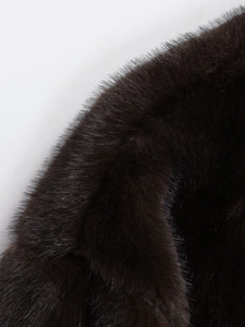 Detail of high-density dark brown faux fur texture with natural gloss on bomber jacket