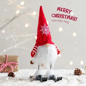 Christmas skiing gnome figurine with red snowflake hat and white beard in festive scene