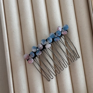 Detail of flower hair comb with pink and blue gradient petals and sparkling rhinestones
