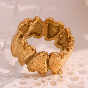 Detail of 18K gold-plated heart ring with water droplet texture on glass surface