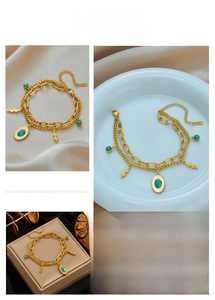 Close-up of gold double-layer chain bracelet featuring turquoise charms and lightning pendants