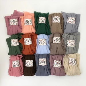 Flat lay of pleated cotton viscose scarves in 15 vibrant colors with numbered labels