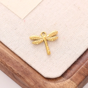 Macro-opname van een gouden libellenhanger met getextureerde vleugels op een jute weefsel