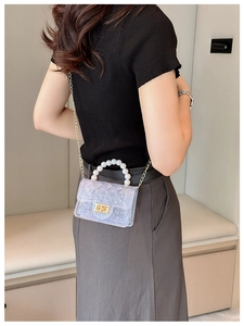 Quilted jelly crossbody bag with elegant pearl handle and gold chain strap on model
