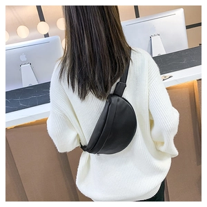 Rear view of model wearing a black half-moon leather chest bag showing capacity and fit