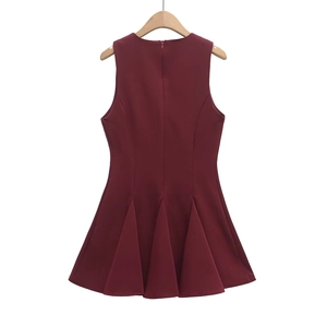 Detail of burgundy sleeveless dress with pleated A-line skirt on a wooden hanger