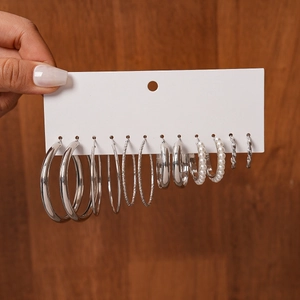Detail view of 9-pair silver hoop earring set with imitation pearls on display card