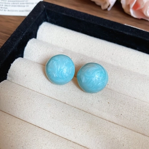 Macro shot of blue vintage floral earrings with marble texture in a jewelry box