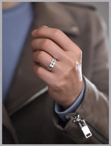 Close-up of vintage Sanskrit silver ring worn by male model with leather jacket