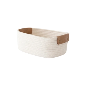 Minimalist woven cotton rope storage basket with brown leather handles on white background