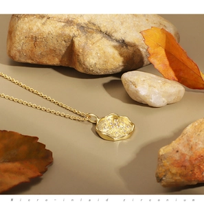 Detailed macro view of gold round pendant with micro-inlaid zirconium on natural background