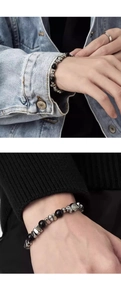 Detail of beaded bracelet with black stones and silver skull charms on a male wrist