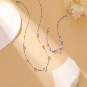 Detail showing elegant silver floral necklace and bracelet with white beaded flower patterns
