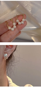 Vista detallada de pendientes de aro con perlas doradas y brazaletes con gemas