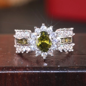 Makroaufnahme Ring mit ovalem olivgrünem Stein, Halo-Design und Silberband