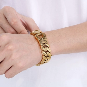 Detailed close-up of golden vintage totem engravings on men's thick stainless steel curb chain