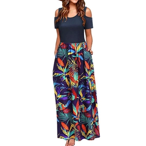 Detail of off-shoulder summer dress with dark blue knit top and tropical leaf print skirt
