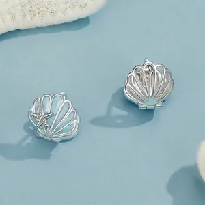Elegant 925 sterling silver starfish shell hoop earrings on a light blue ocean background