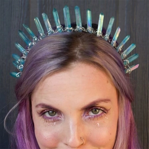 Detailed view of iridescent raw crystal crown headband on model with purple hair