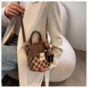 Detail of checkered shoulder bag with golden twist lock and a cute rabbit pendant