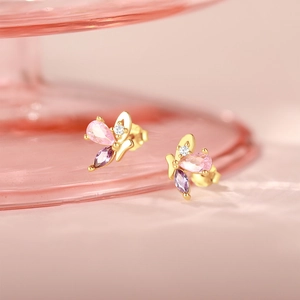 Close-up of butterfly stud earrings with pink and purple zircon stones in gold finish