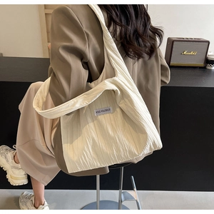 Detailansicht der beigen Falten-Schultertasche mit KISS YOURSELF Textiletikett