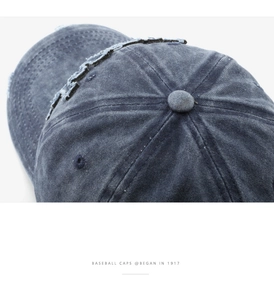 Close-up of distressed washed navy blue cotton baseball cap with vintage embroidery