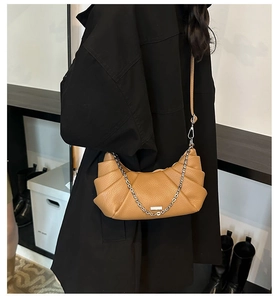 Detail of camel crescent crossbody bag with pleated texture and silver chain strap
